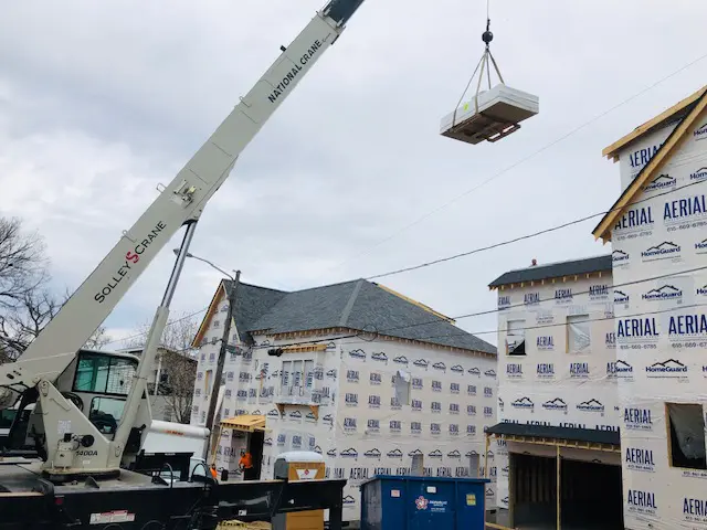 A crane is lifting a box in the air.