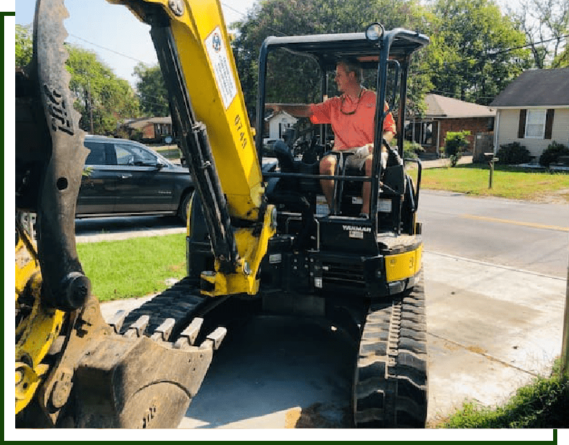 Man operating yellow excavator on tracks.